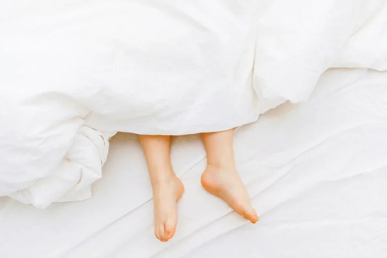 Đôi chân bé trên ga giường trắng